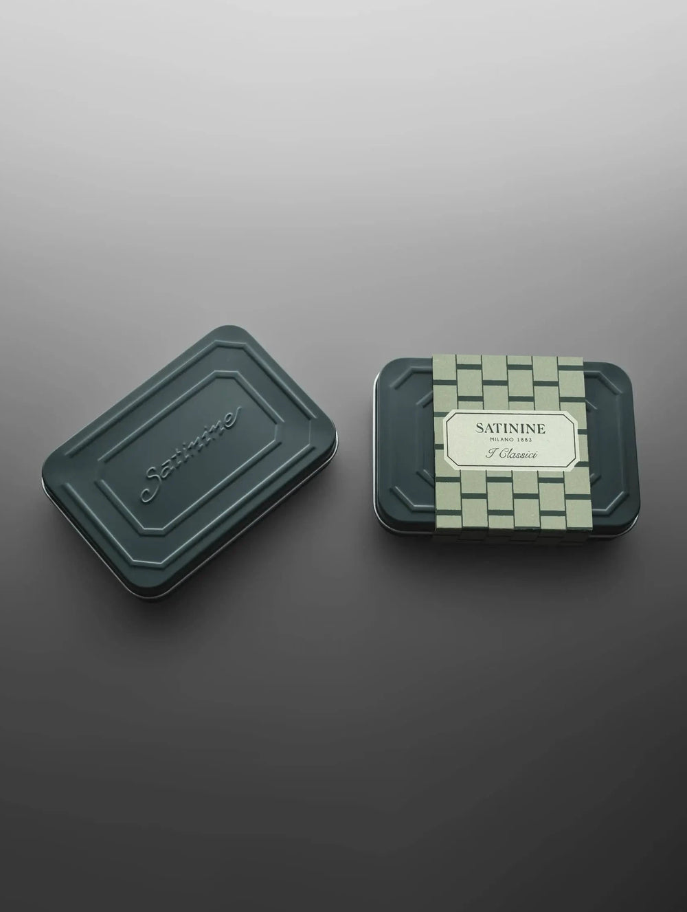 Two green containers on a reflective gray surface